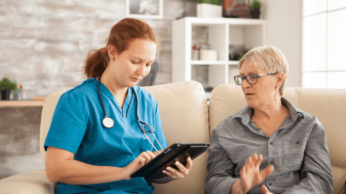 Female doctor using tablet computer and older woman 