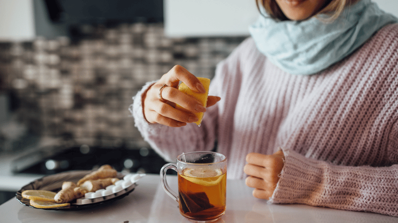 Woman squeezing lemon into tea
