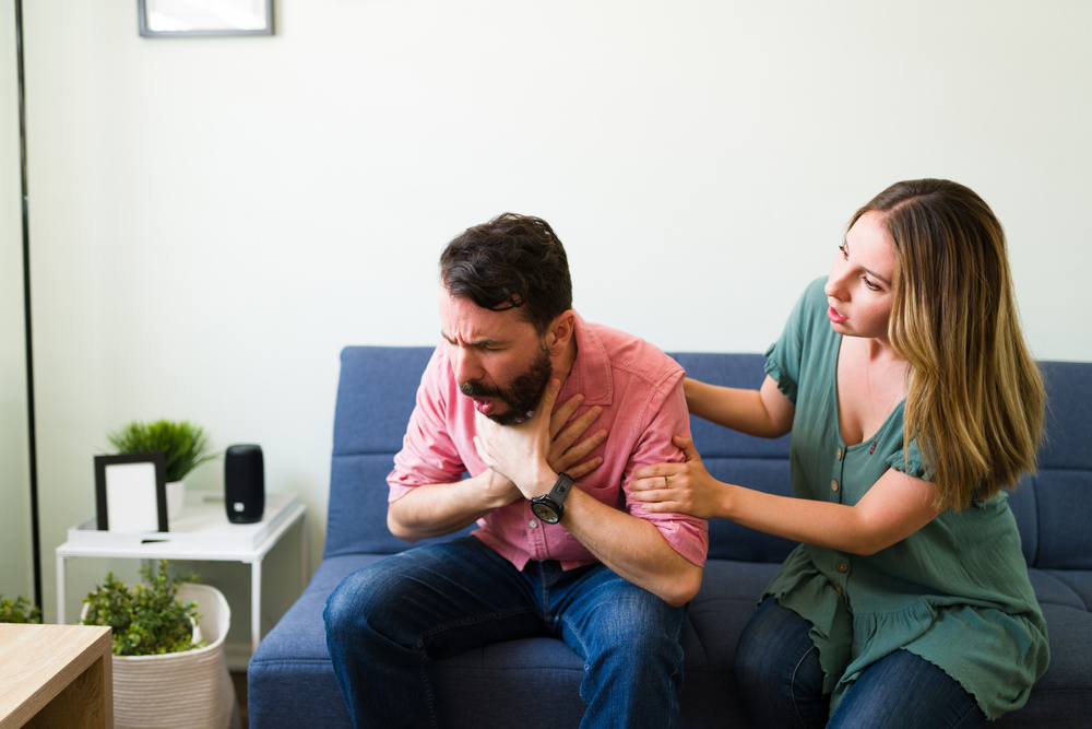 Adult latin man choking with a piece of food 