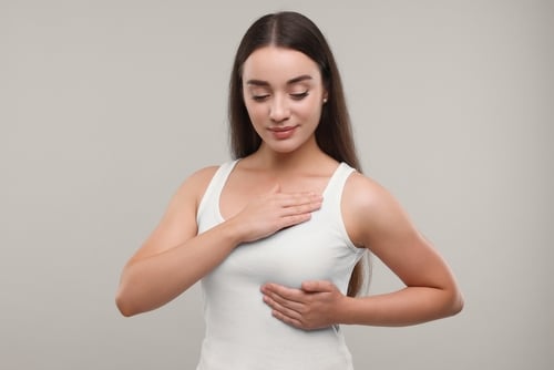 A woman showing care to her breast