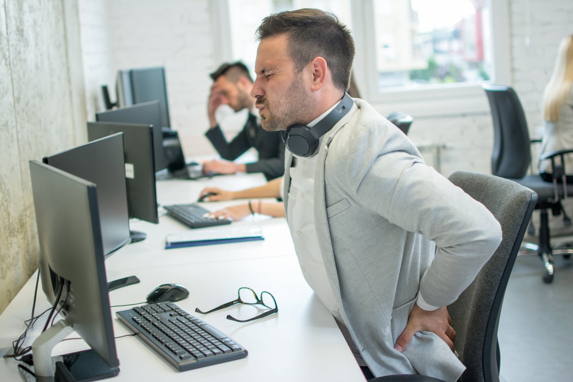 Businessman suffering from backache in office