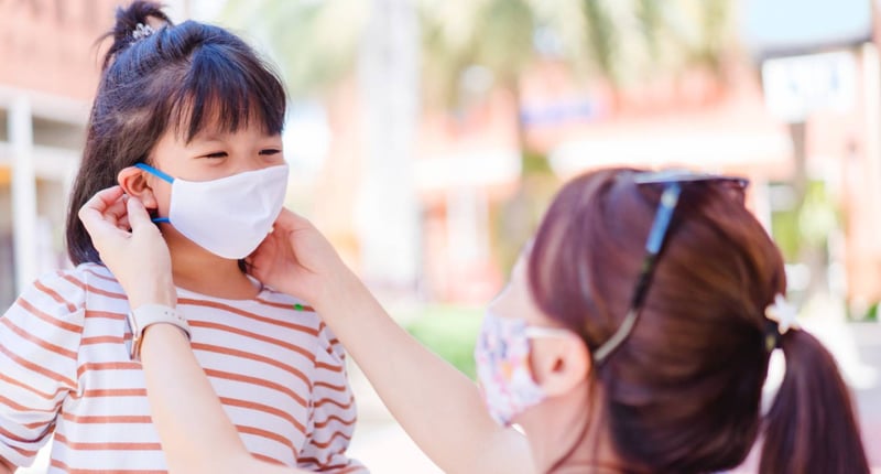 母親為女兒佩戴口罩預防新冠肺炎