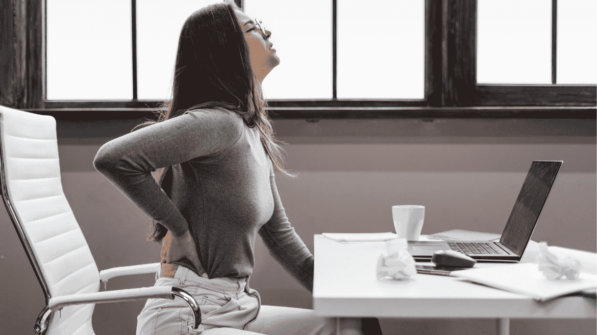 腰痛的女士坐在桌子前