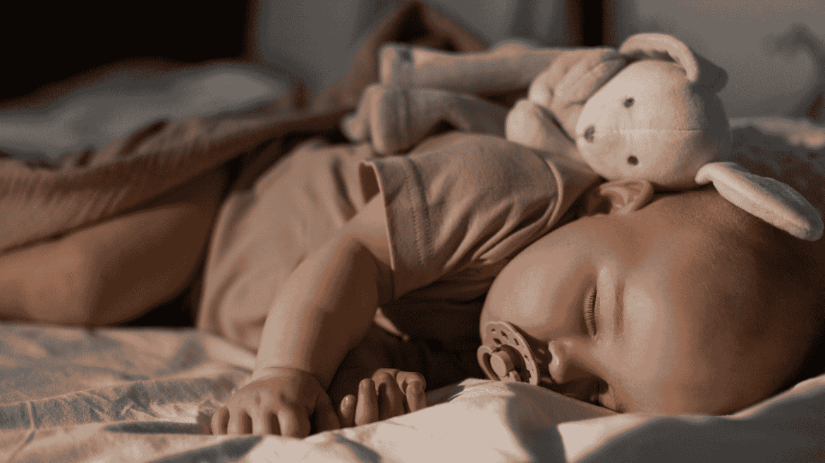A baby is sleeping with a rabbit toy