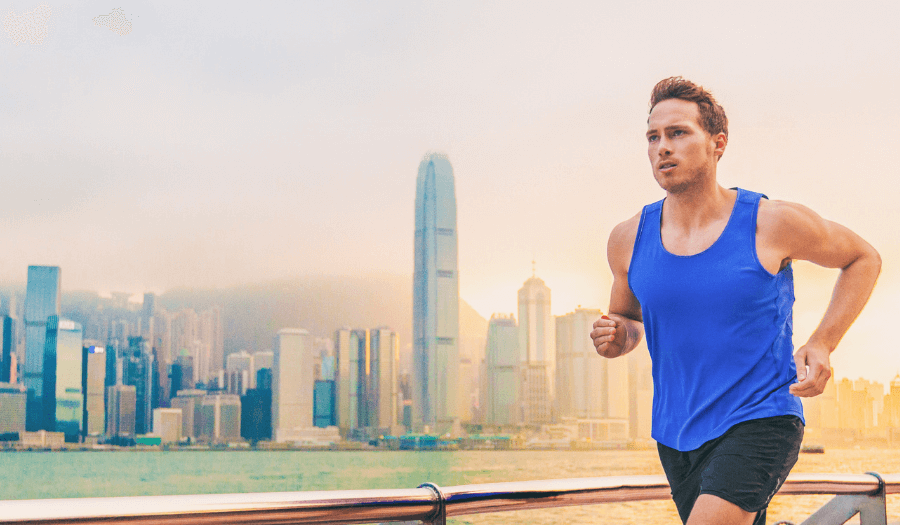 A man running with the backdrop of Victoria Harbour, Hong Kong showing