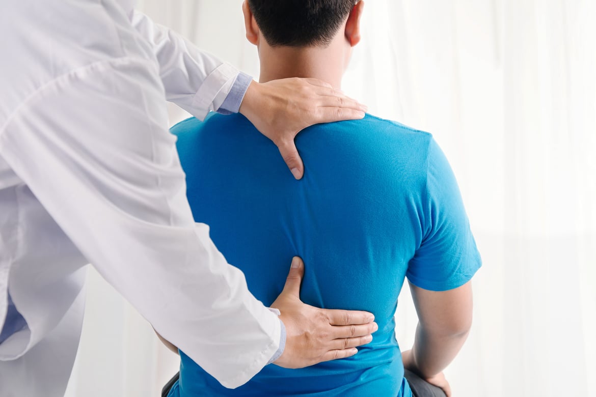 Physiotherapist fixing a man's back