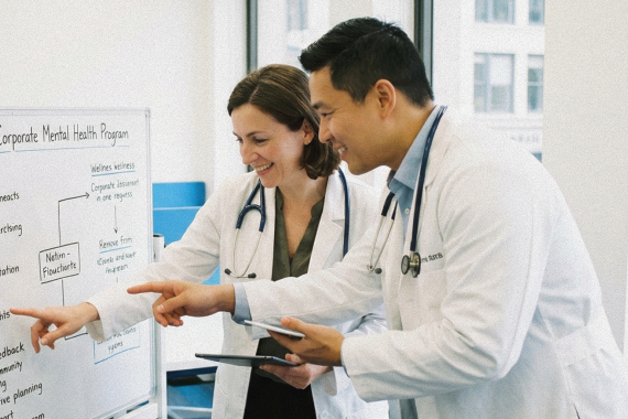 two doctors pointing at whiteboard-1