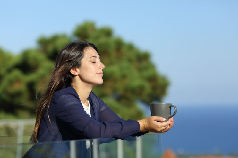A lady is relaxing with harbor view and a cup of coffee 