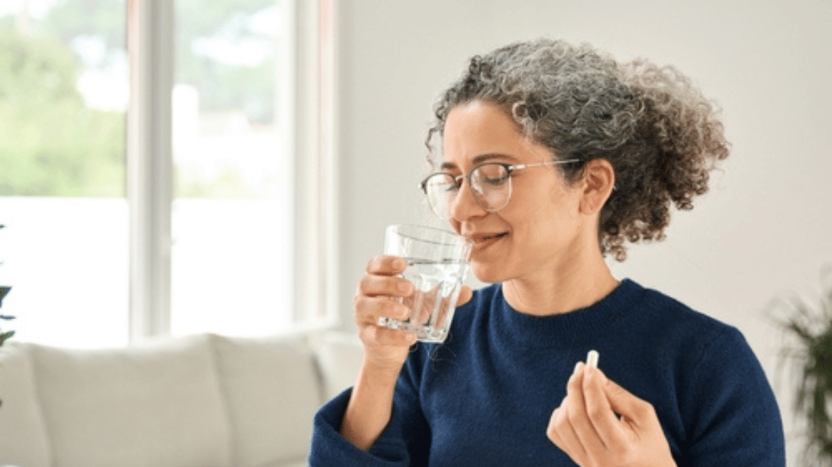Middle aged woman taking a supplement for her health