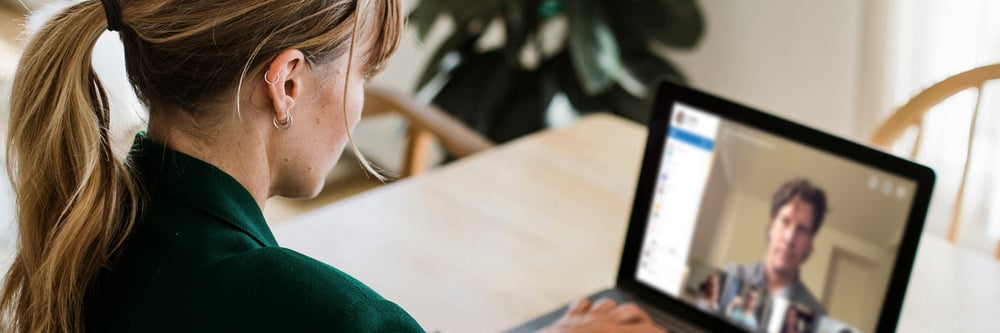 A woman in a virtual meeting and working from home.