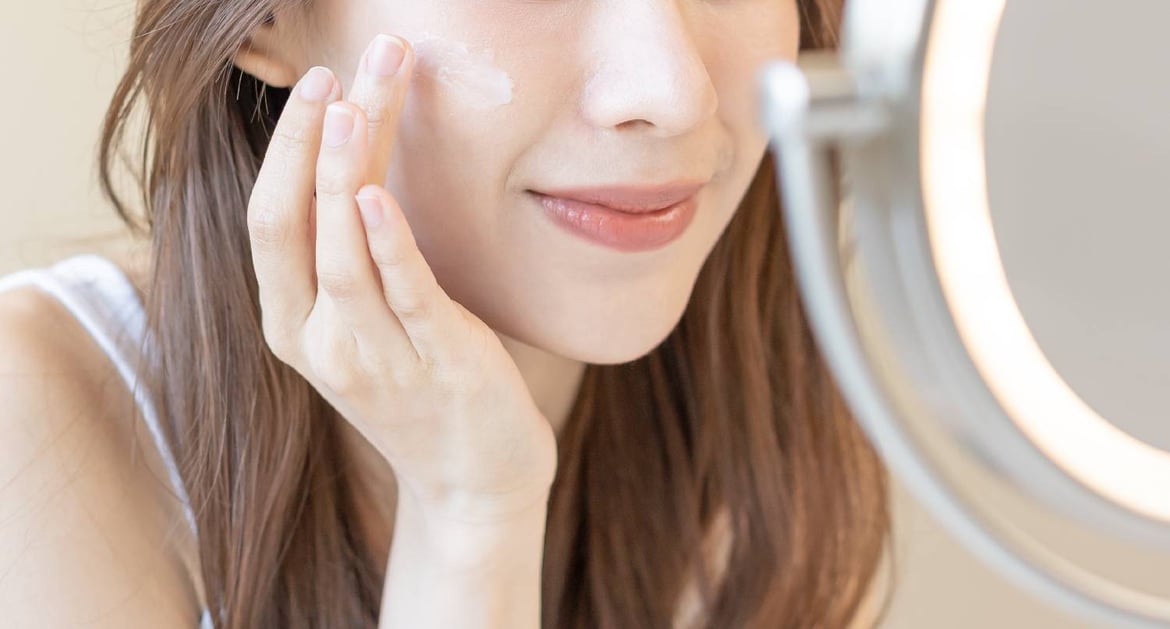 年輕女子塗護膚品