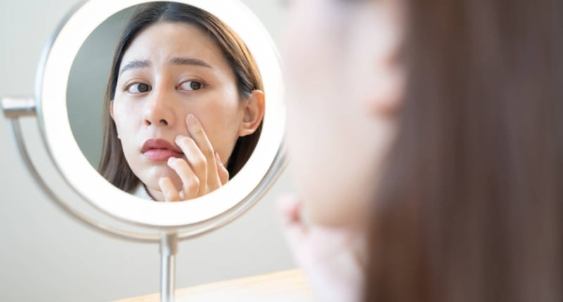 年輕女子在鏡子看到黑眼圈