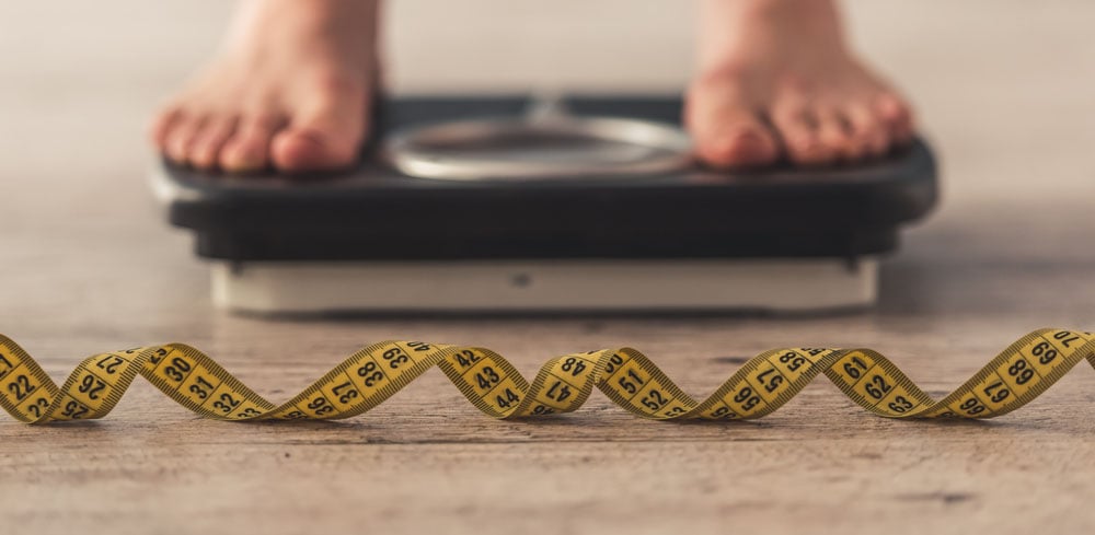 Male weighing on scale