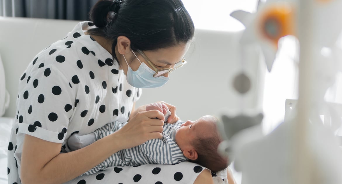 戴口罩的媽媽和嬰兒玩耍