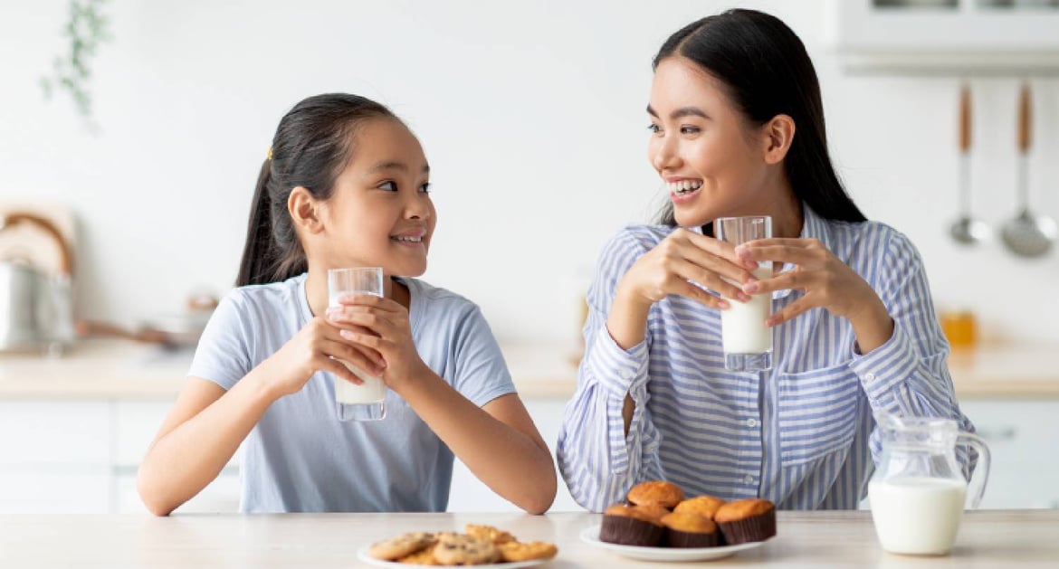 在家中喝牛奶的母女