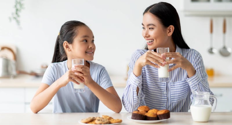 在家中喝牛奶的母女