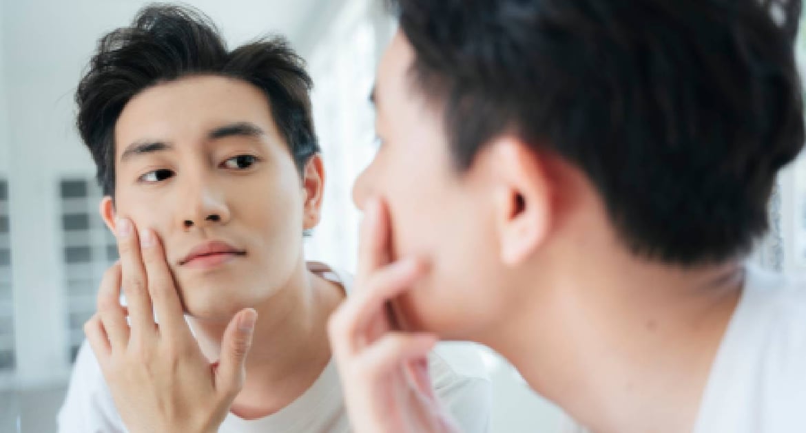 年輕男子在鏡子前檢查面上毛孔