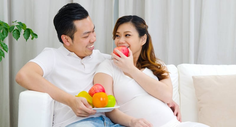 孕婦在家中與丈夫吃水果