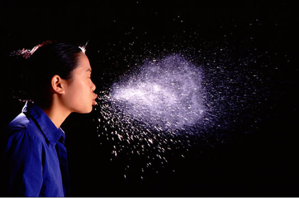 virus spreading through woman sneezing