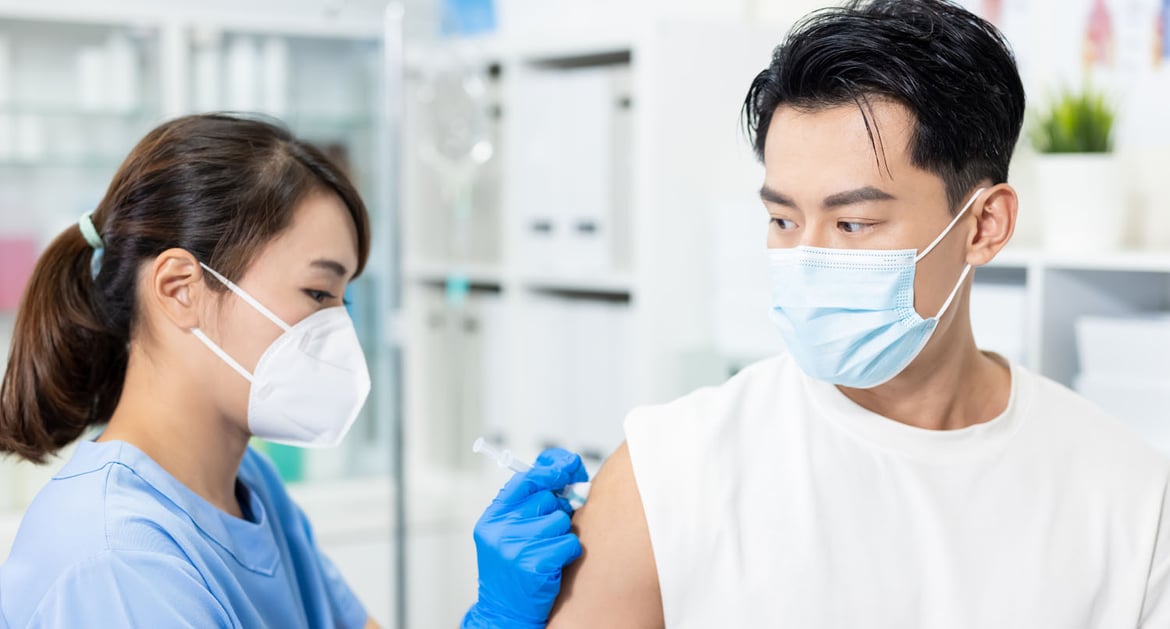 醫護人員為年輕男士接種新冠疫苗