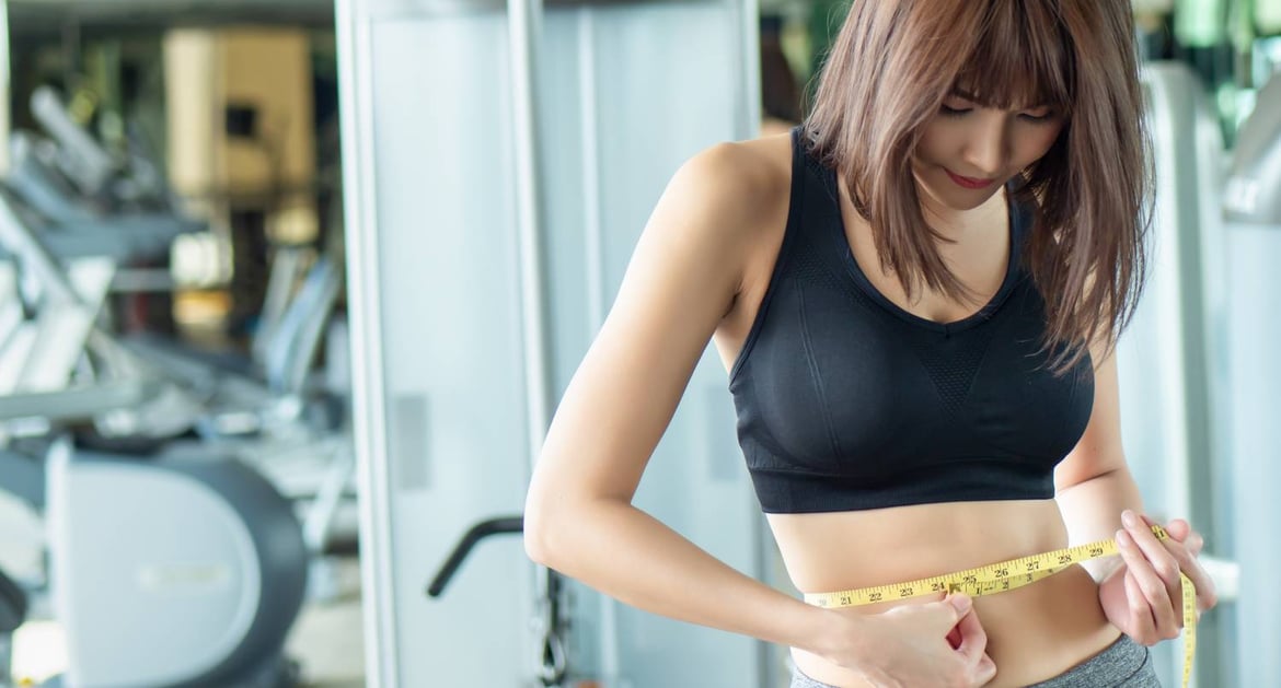 年輕女性在健身室量度腰圍