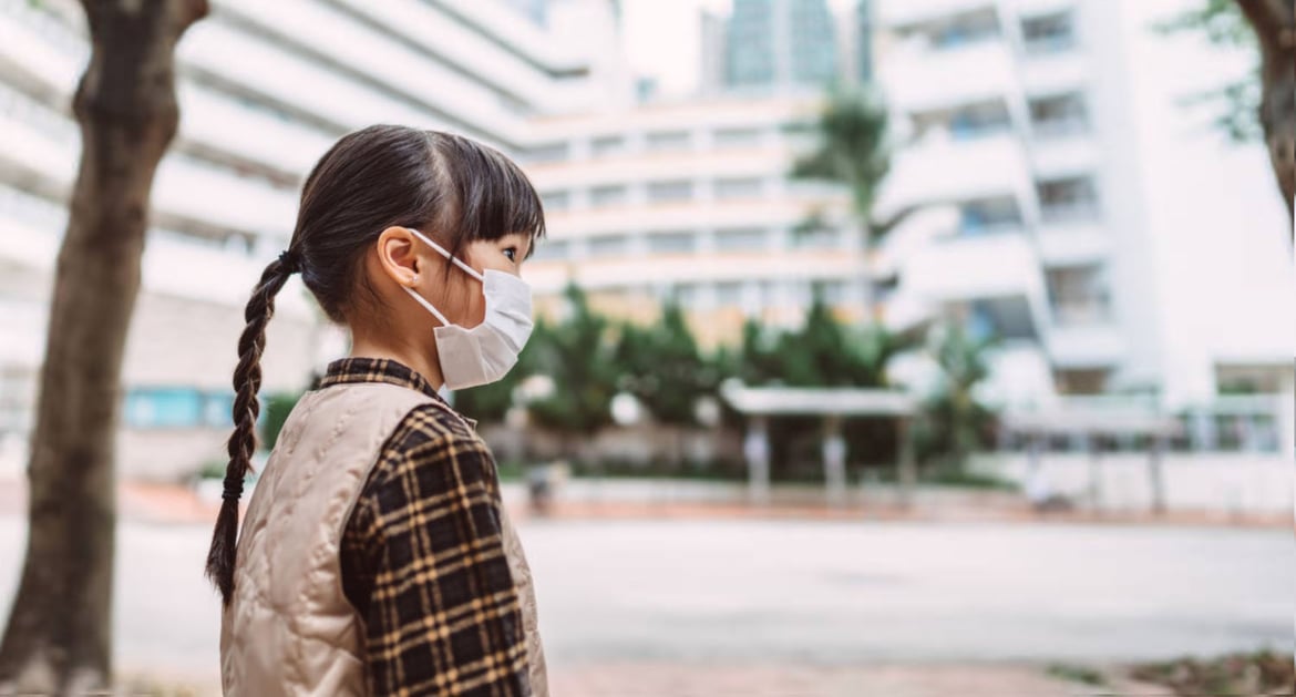 A young girl wearing mask looking at school closure due to Hong Kong Covid restrictions.