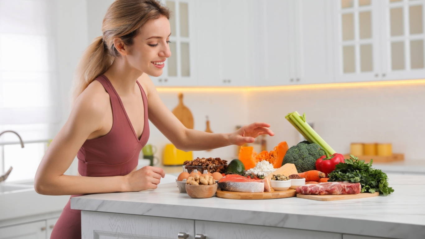 Woman with healthy food in kitchen. Keto diet