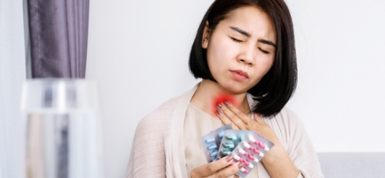 女士喉嚨痛拿著許多藥