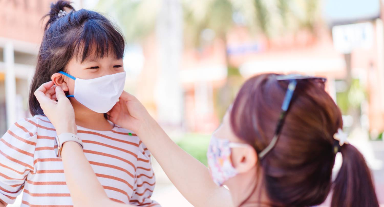 母親為女兒佩戴口罩預防新冠肺炎