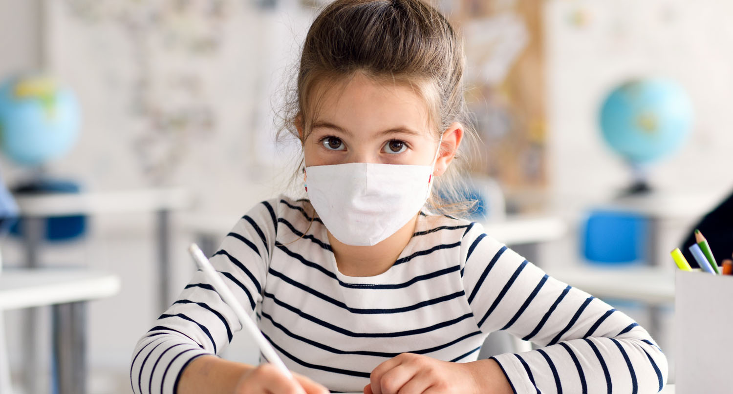 Child wearing mask while studying