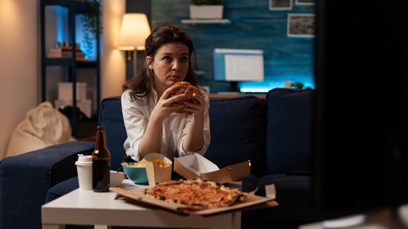 woman eating junk food on couch