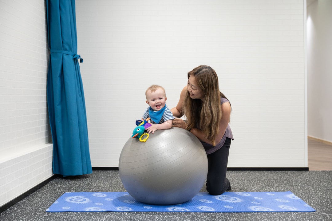 Physiotherapist working with a baby on motion