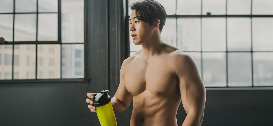 man drinking creatine at a gym 