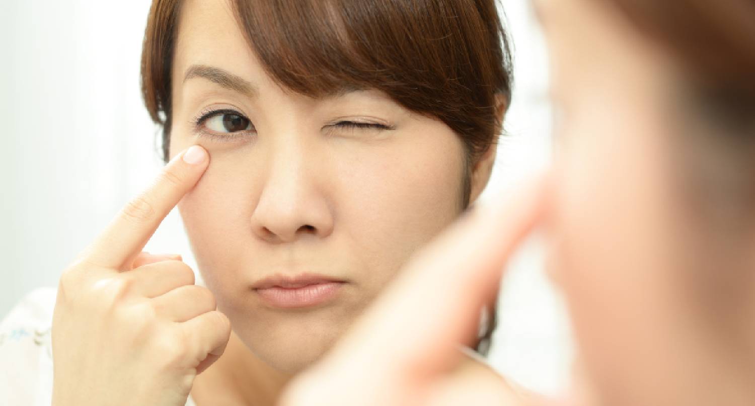 在鏡中看自己眼袋的女性