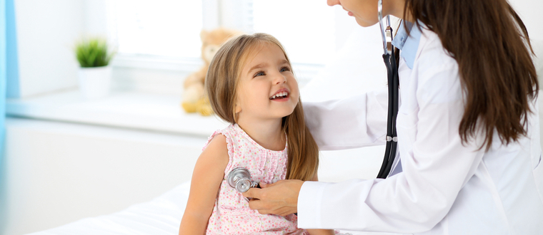 A doctor checking the heartbeat of a child.