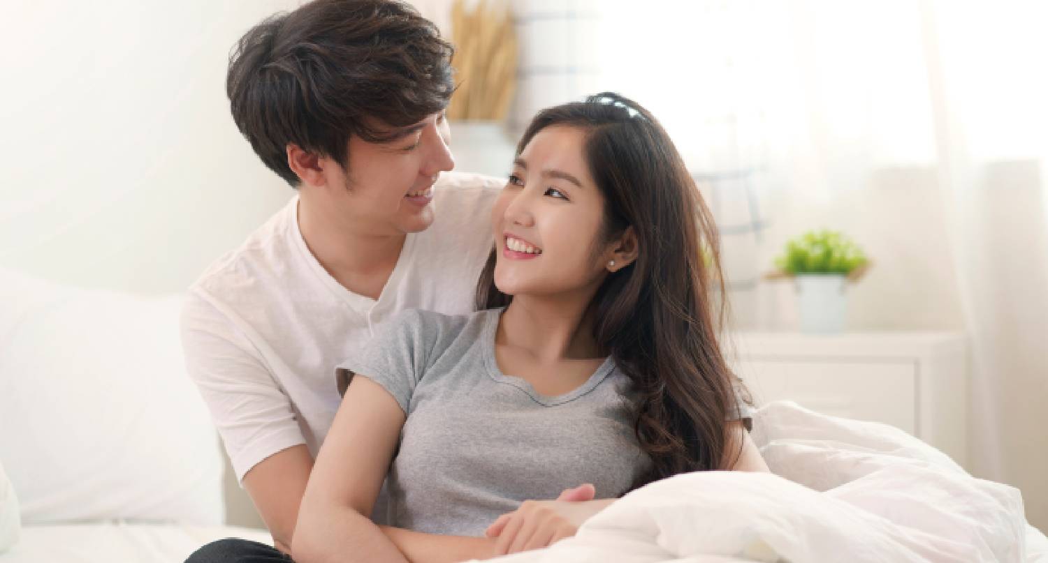 年輕情侶在床上相擁