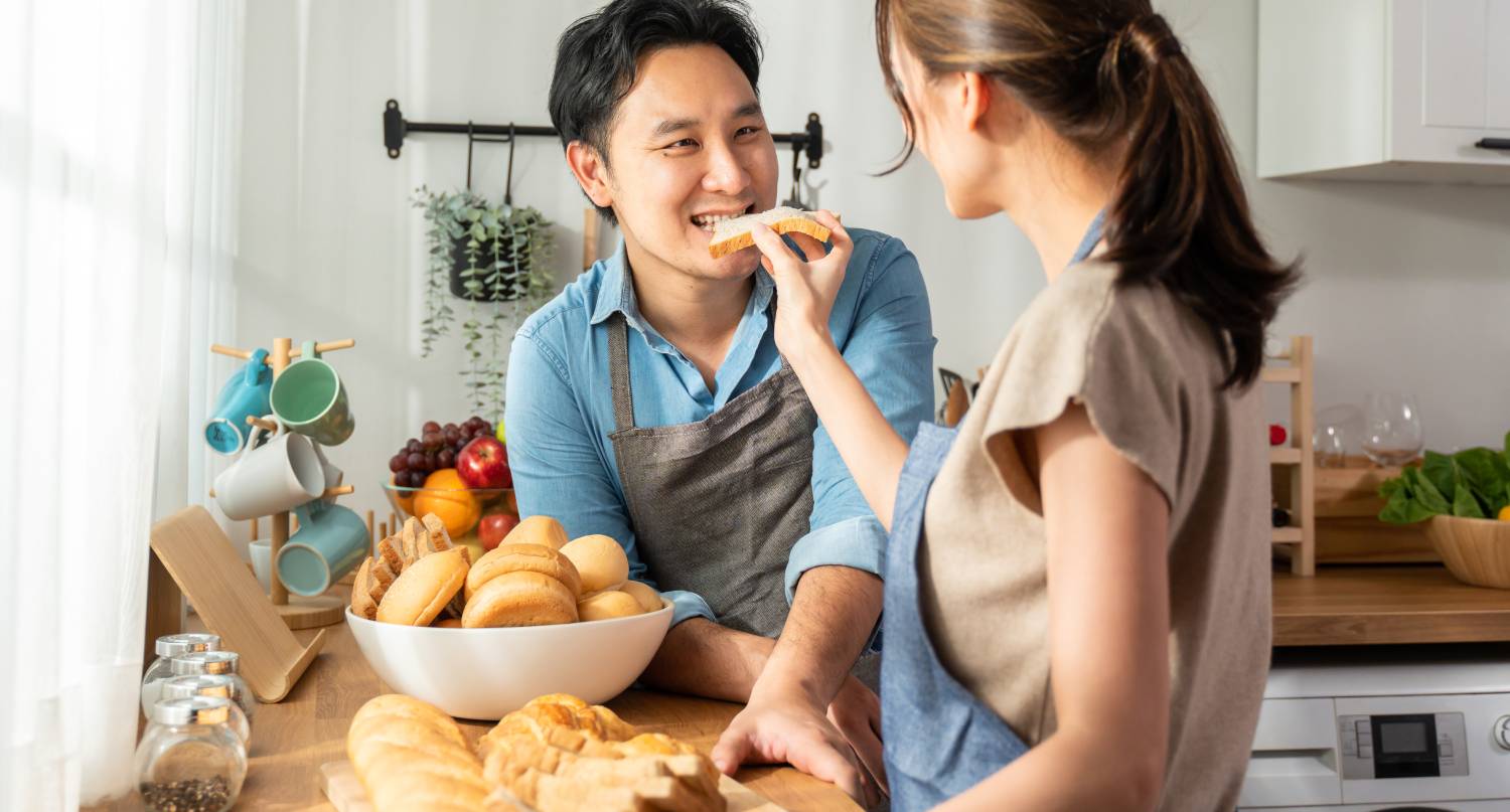 年輕婦女餵丈夫吃麵包