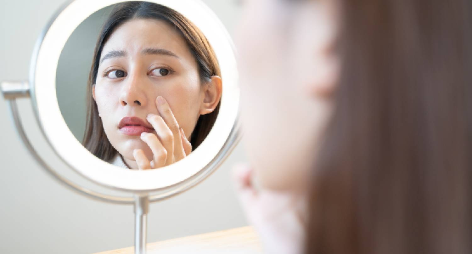 年輕女子在鏡子看到黑眼圈