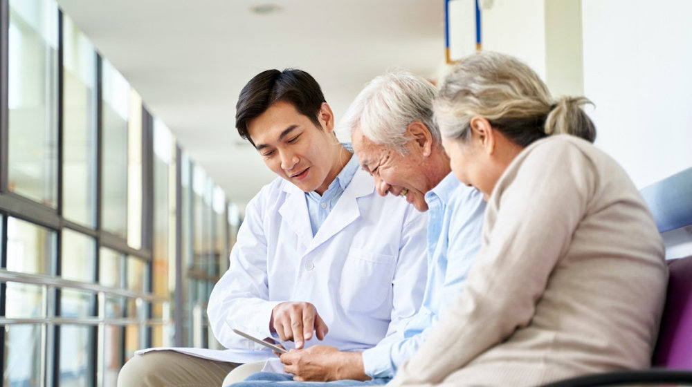Doctor talking to older patient and his wife