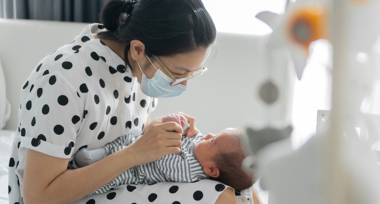 戴口罩的媽媽和嬰兒玩耍