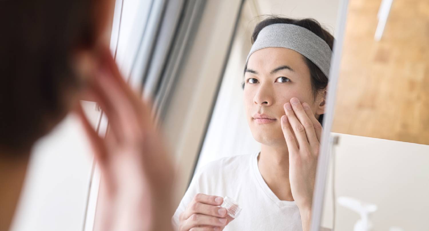 在鏡子前洗面的年輕男士