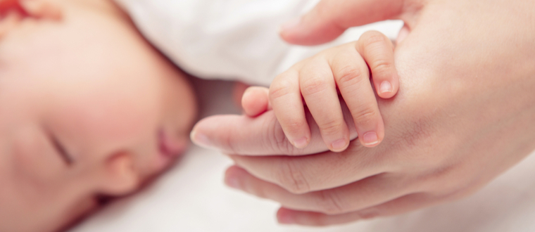 new mom holding baby hand