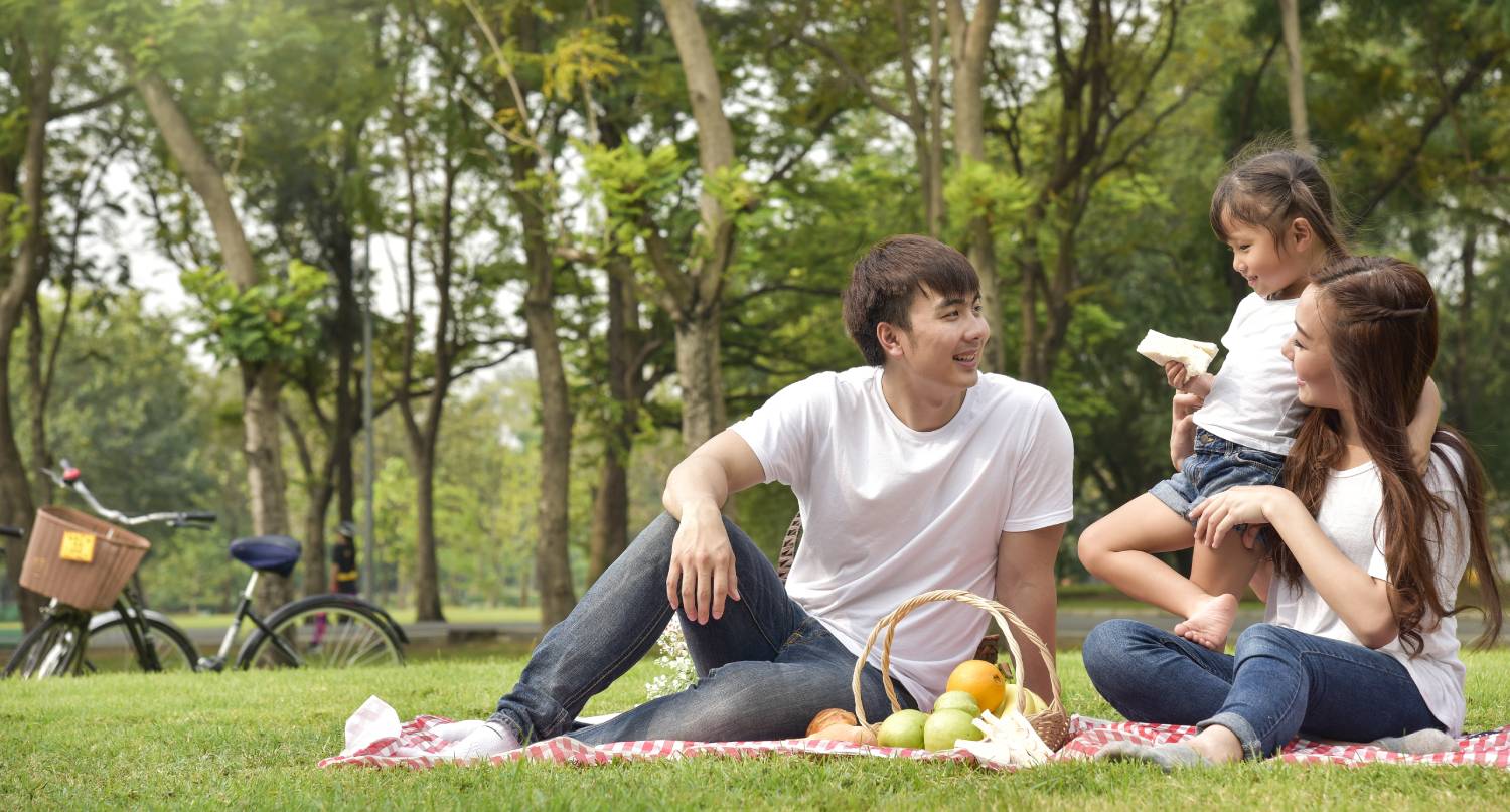 年輕父母和女兒在公園遊玩