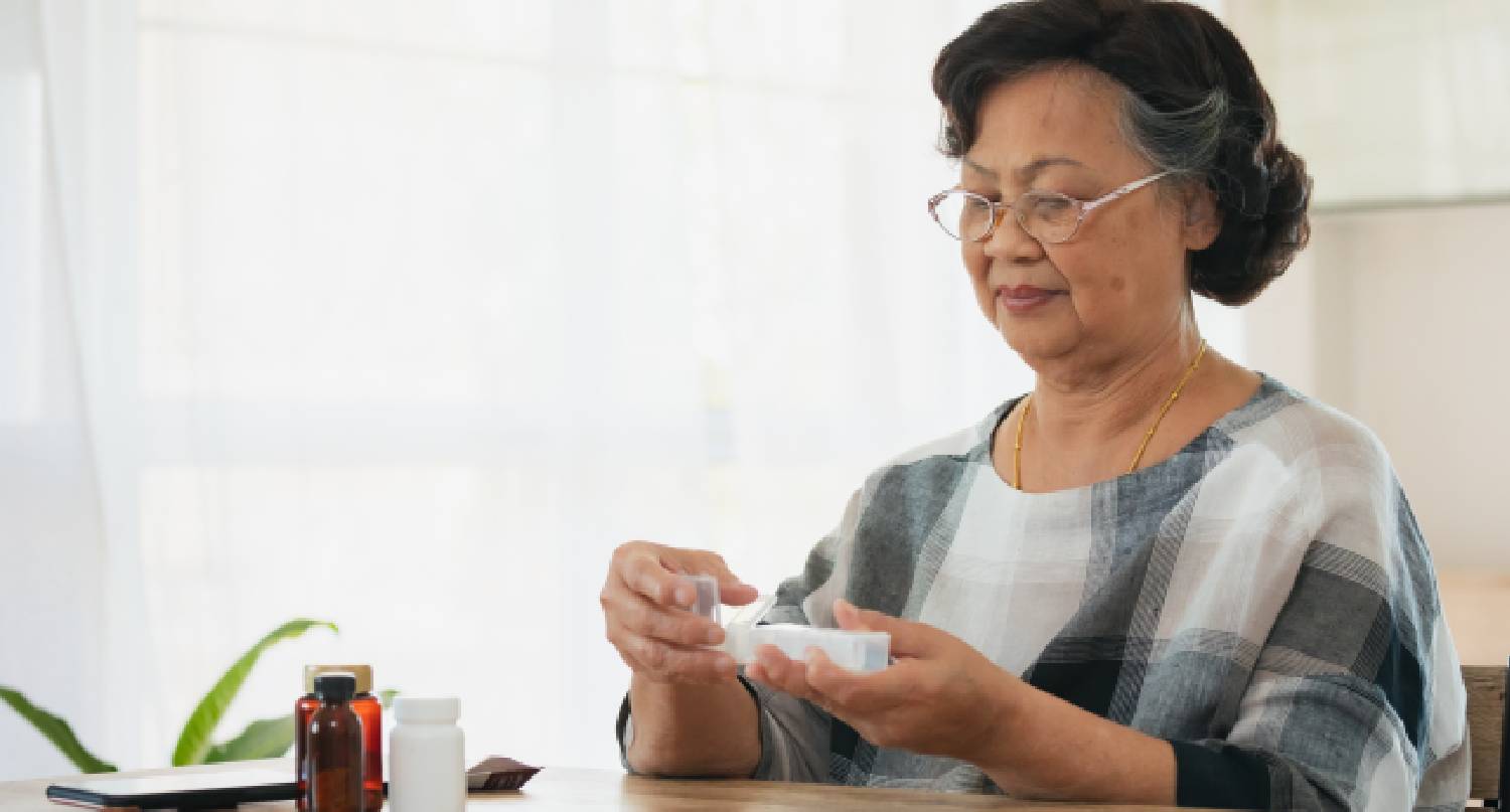 年老女人收拾營養補充劑